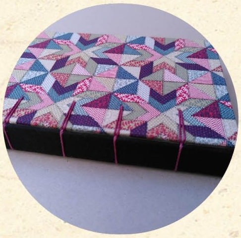 Reliure Belge sur cartonnage en tissu à motif géométrique rose, bleu et violet - Cosette Cartonera