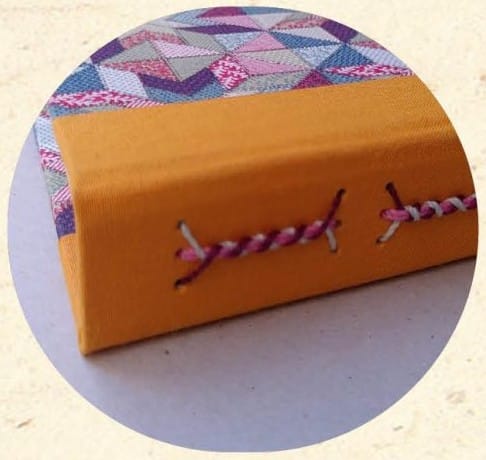 Reliure Long Stitch sur cartonnage à motif triangles roses et violets - Cosette Cartonera